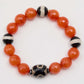 Bracelet with orange and black beads on a white background