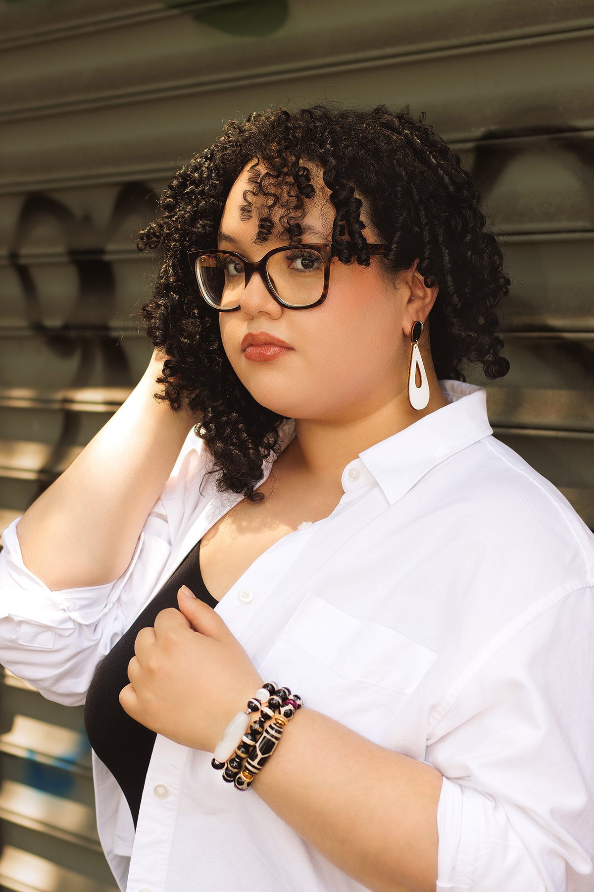 Woman wearing glasses and a white shirt against a blurred background