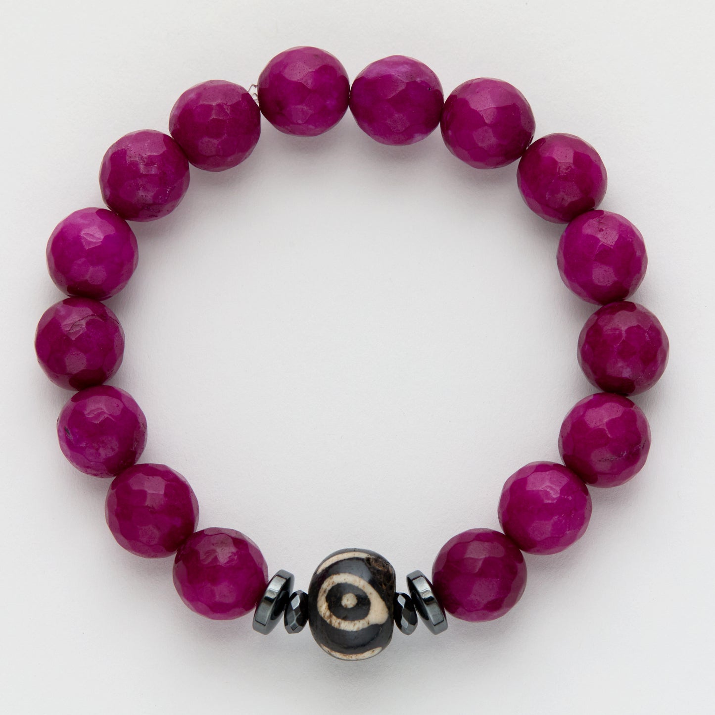 Purple beaded bracelet with a black and off-white focal bead on a white background