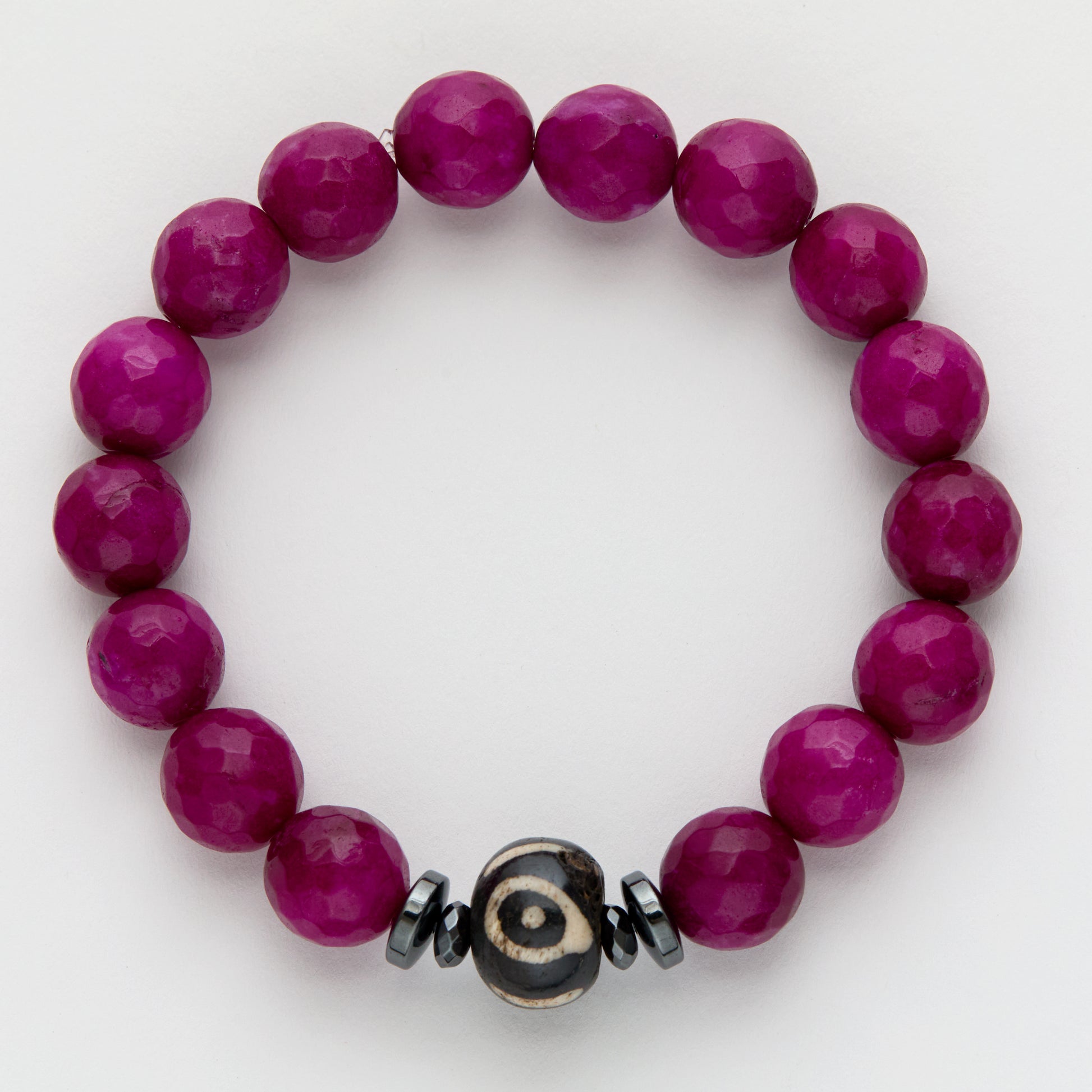 Purple beaded bracelet with a black and off-white focal bead on a white background