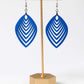 Blue earrings on a gold stand against a white background