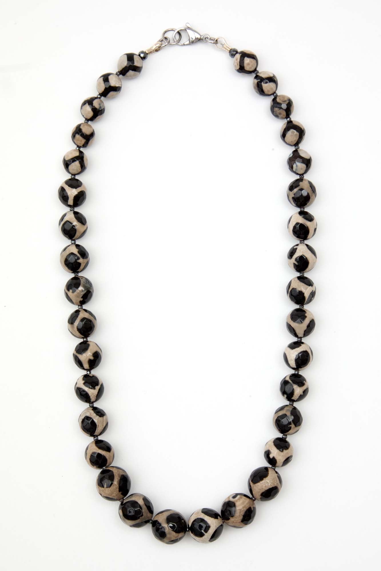 Necklace with black and white patterned beads on a white background