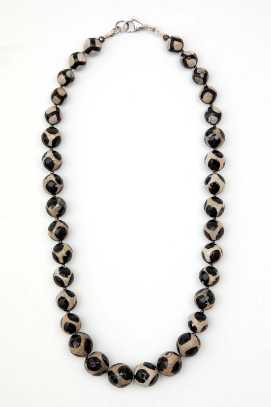 Necklace with black and white patterned beads on a white background