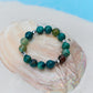 Green beaded bracelet on a large shell with a blue background