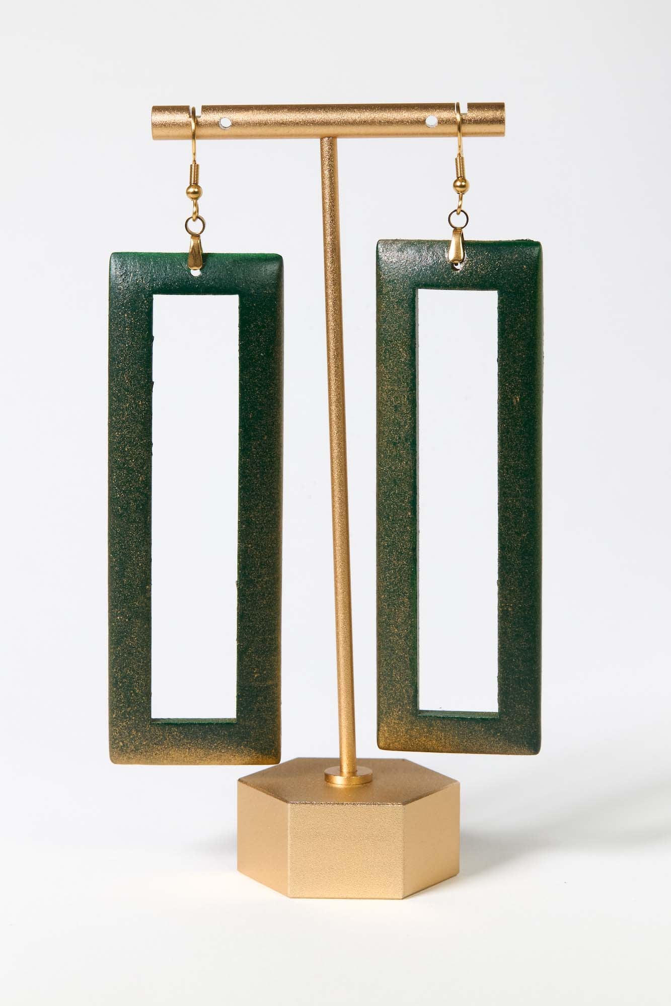 Green open rectangle earrings on a gold stand against a white background